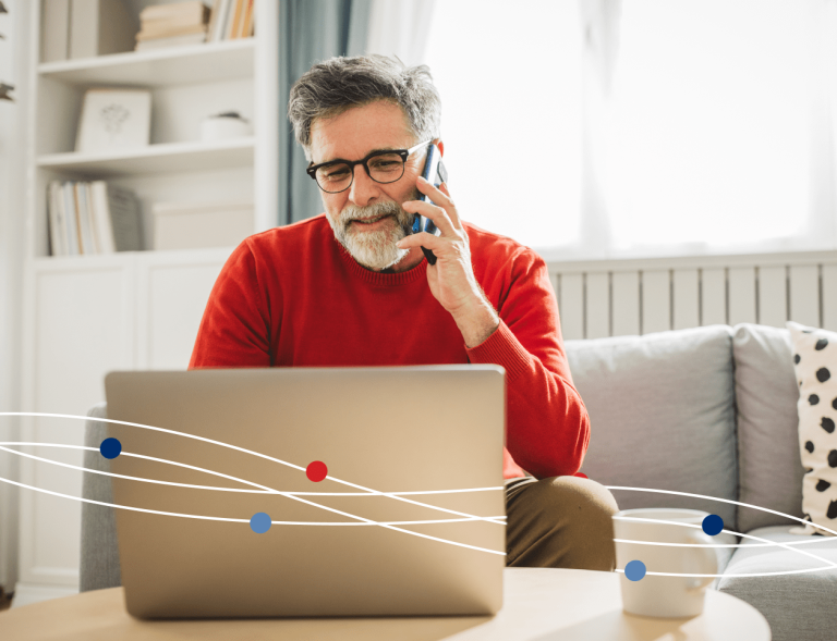 Man talking on phone and using laptop